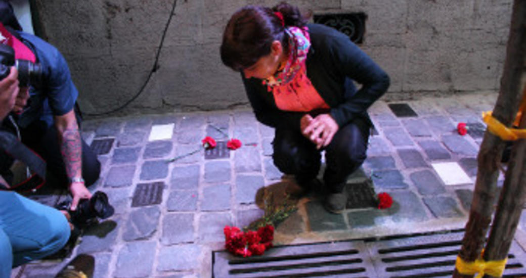 Susana Zúñiga pone flores en la placa que recuerda a su padre, Eduardo Zúñiga.